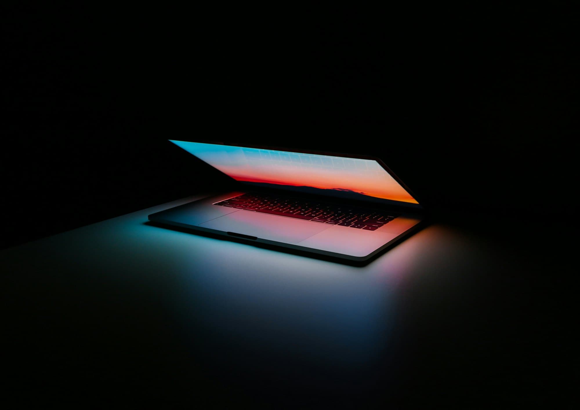 Laptop glowing in a dark room